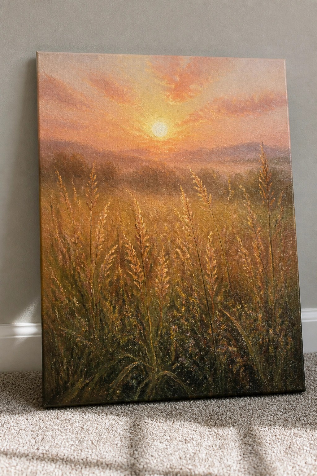 Golden field of tall grass at sunset with glowing sun and misty hills.