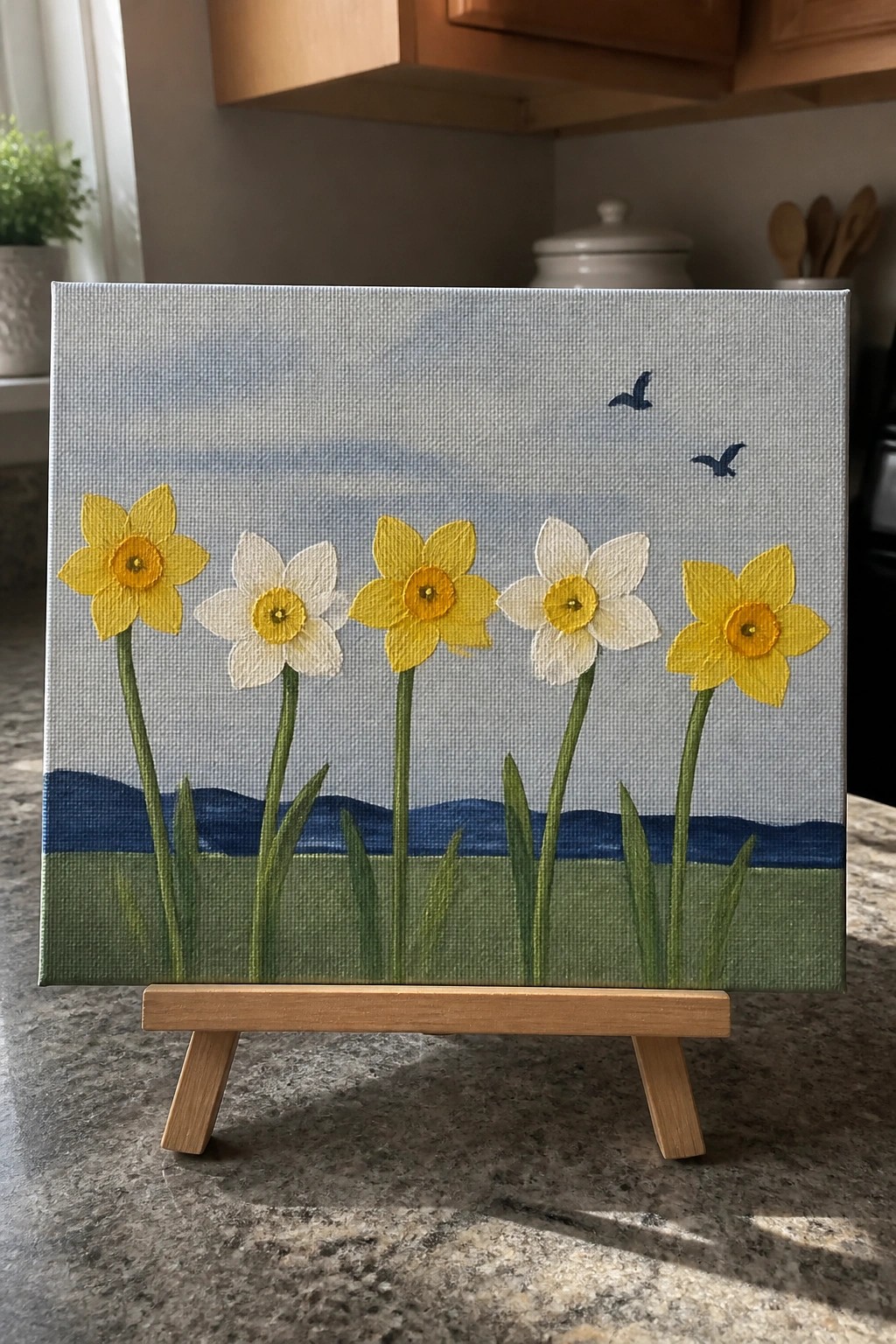 Miniature painting of five yellow and white daffodils on a wooden easel.