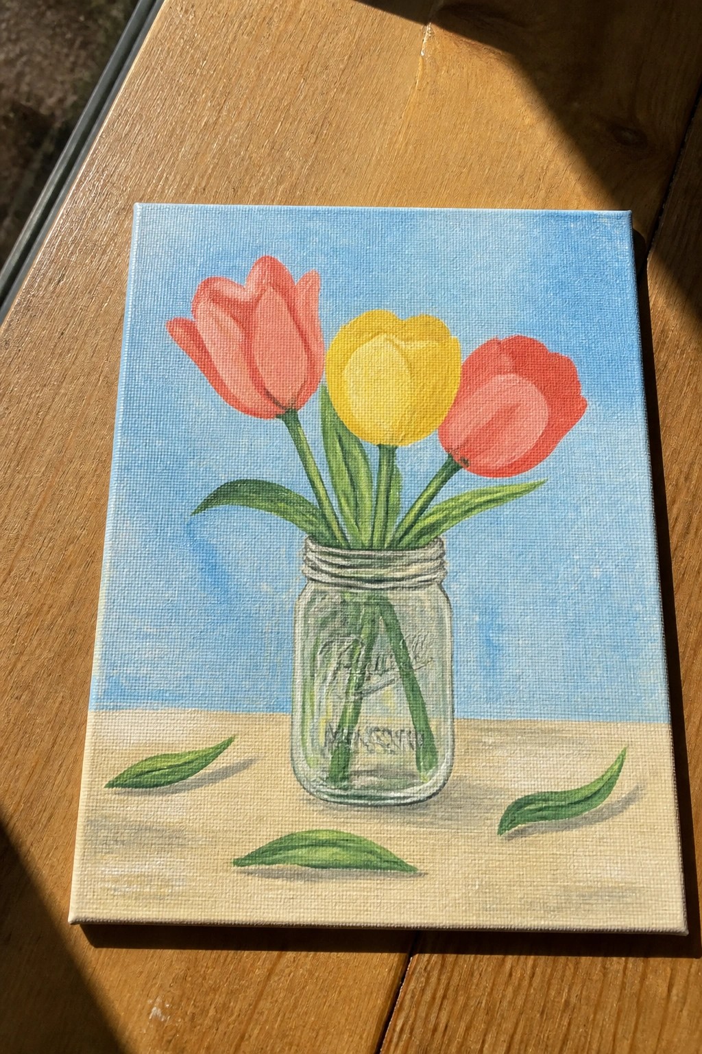 Painting of three tulips in a mason jar with scattered leaves.