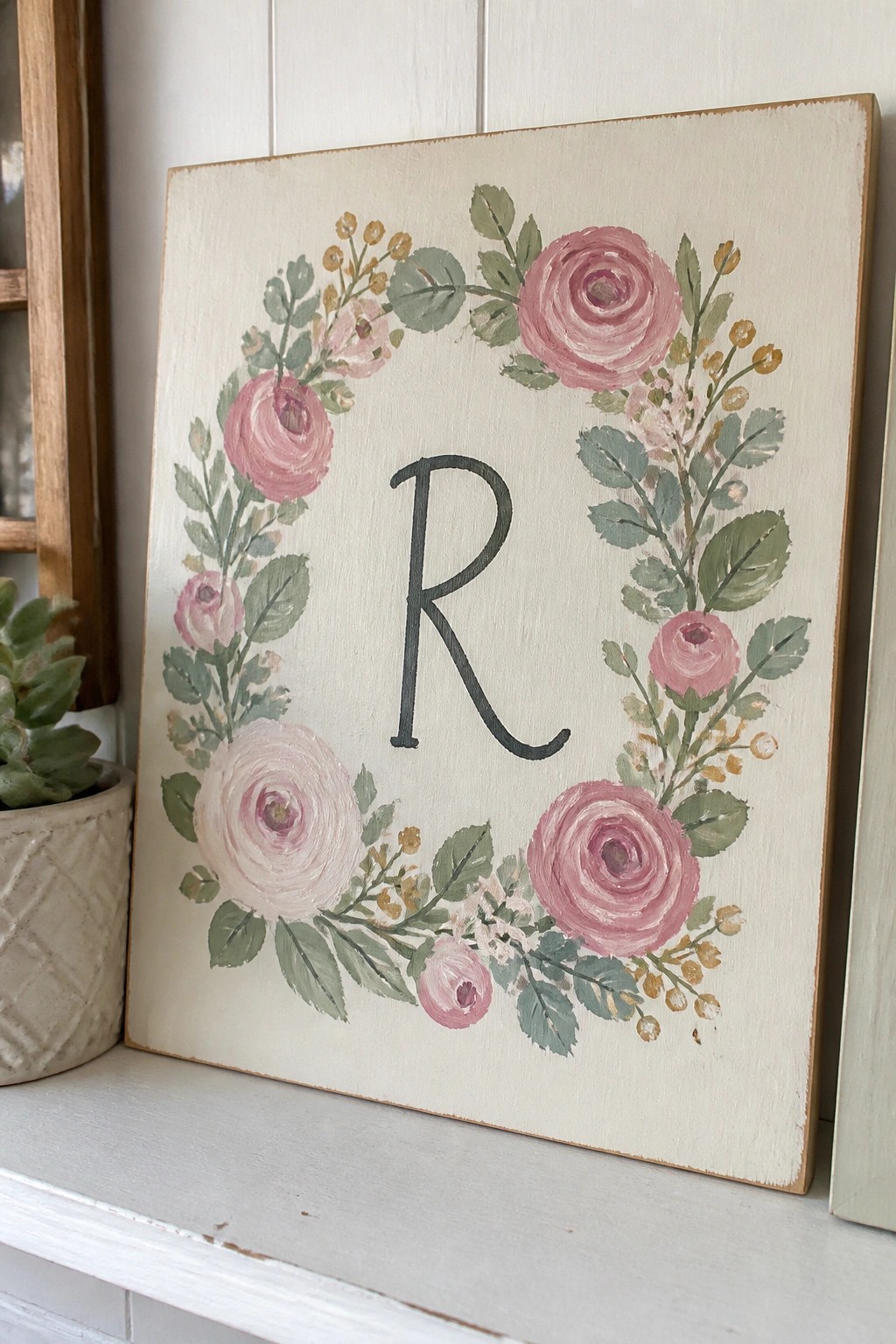 Rustic wooden sign with pink rose wreath and centered black letter R