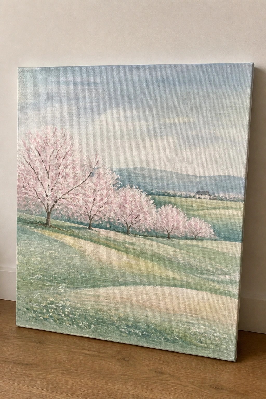 Pastel landscape with pink cherry blossoms along a winding path in rolling green fields