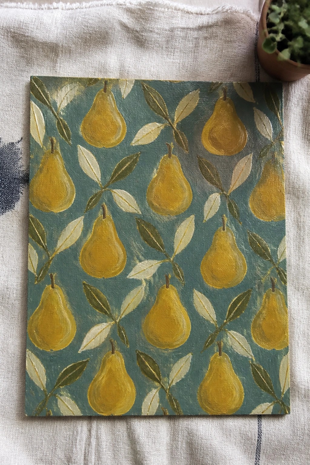 Yellow pear and leaf pattern painting on teal canvas over white fabric