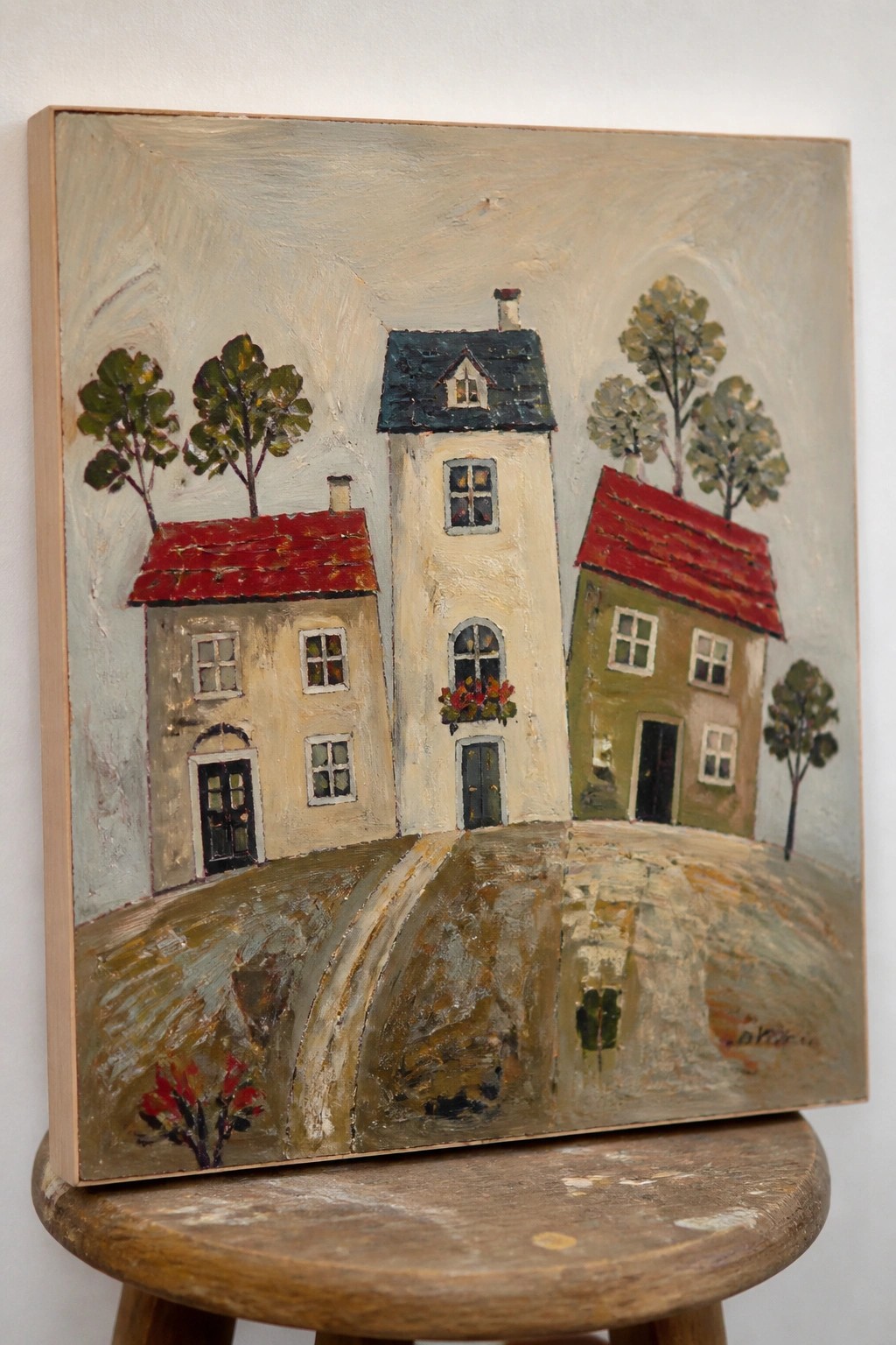 Painting of three houses with red roofs, trees, and winding path.