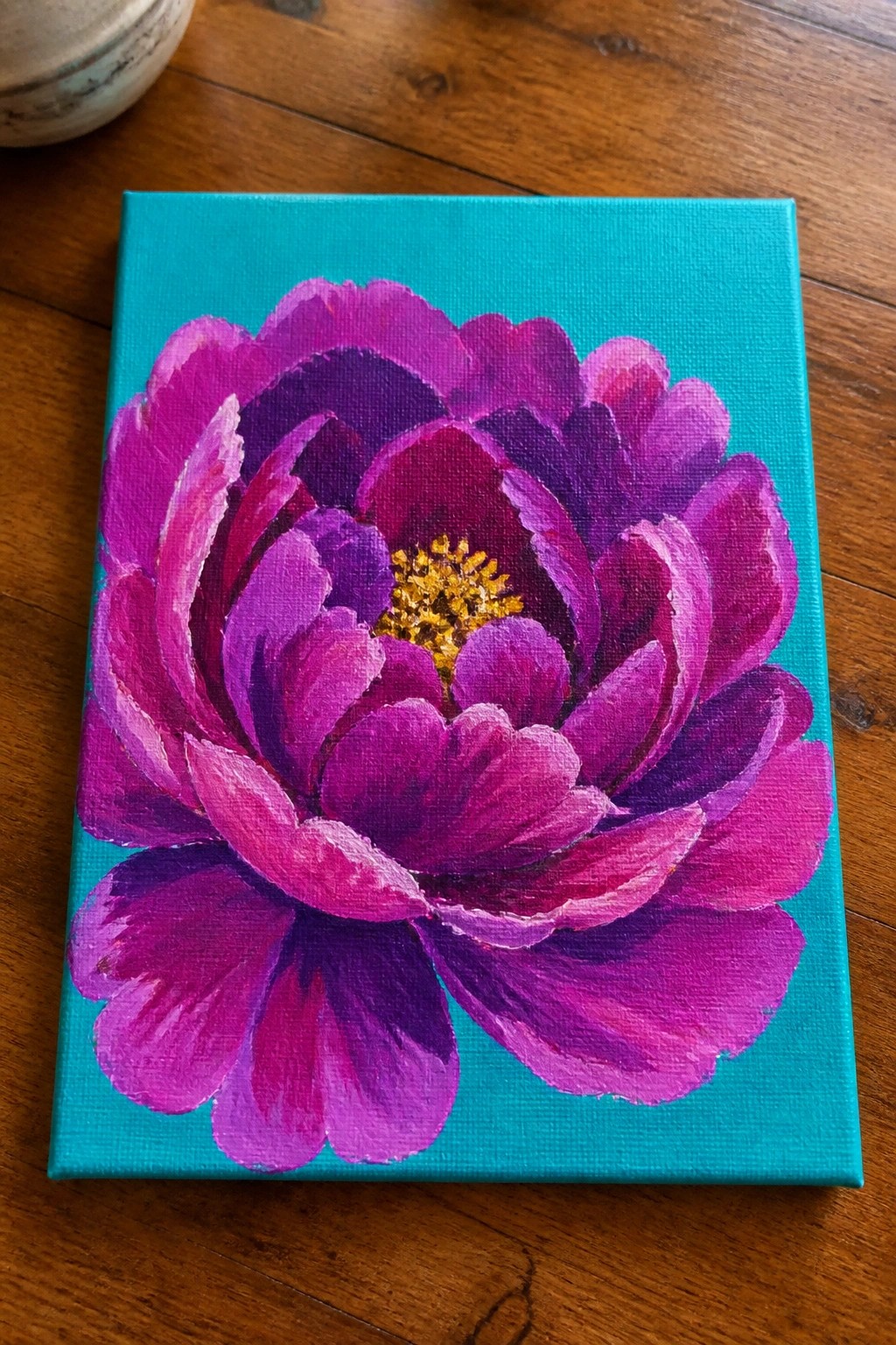 Vivid purple peony with yellow center painted on turquoise canvas.