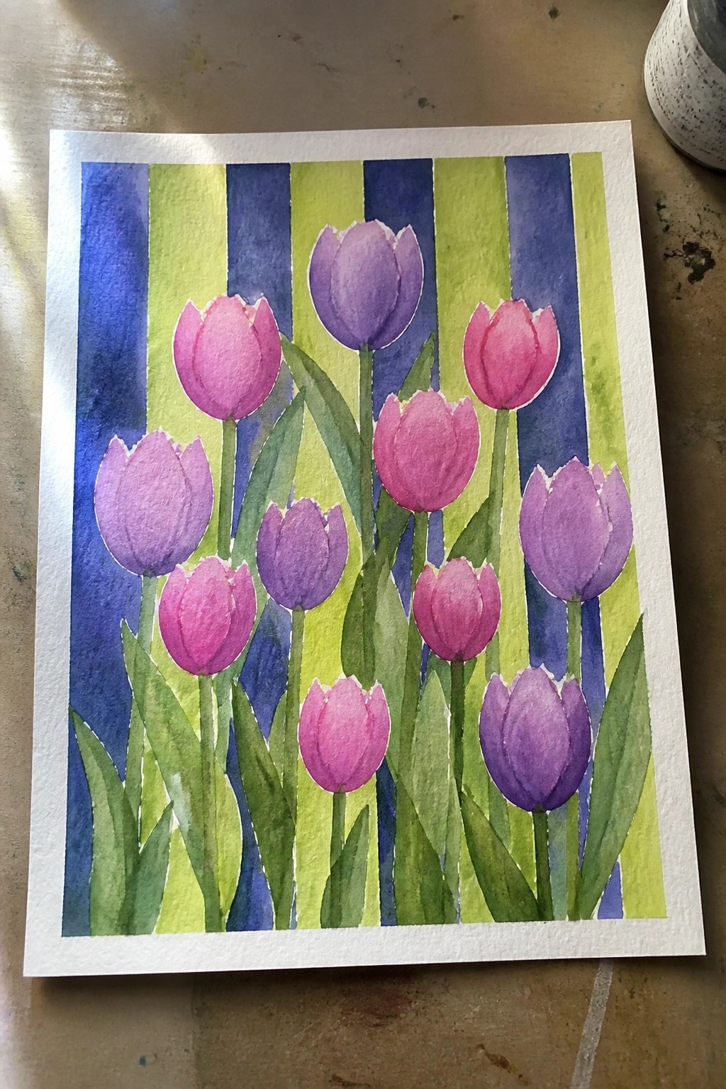 Watercolor painting of pink and purple tulips on vertical blue and green stripes