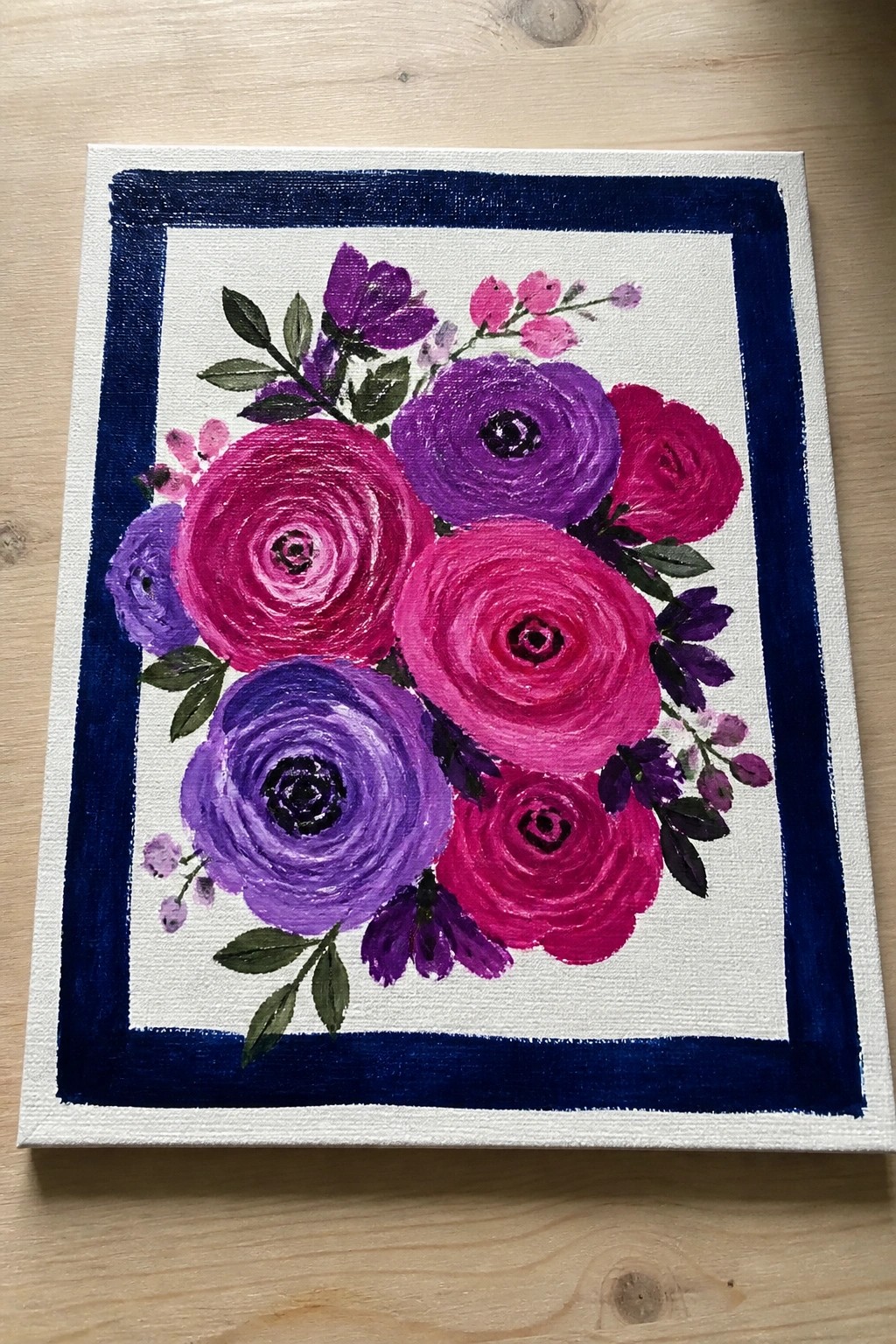Vibrant painting of pink purple flowers with green leaves on canvas with blue border