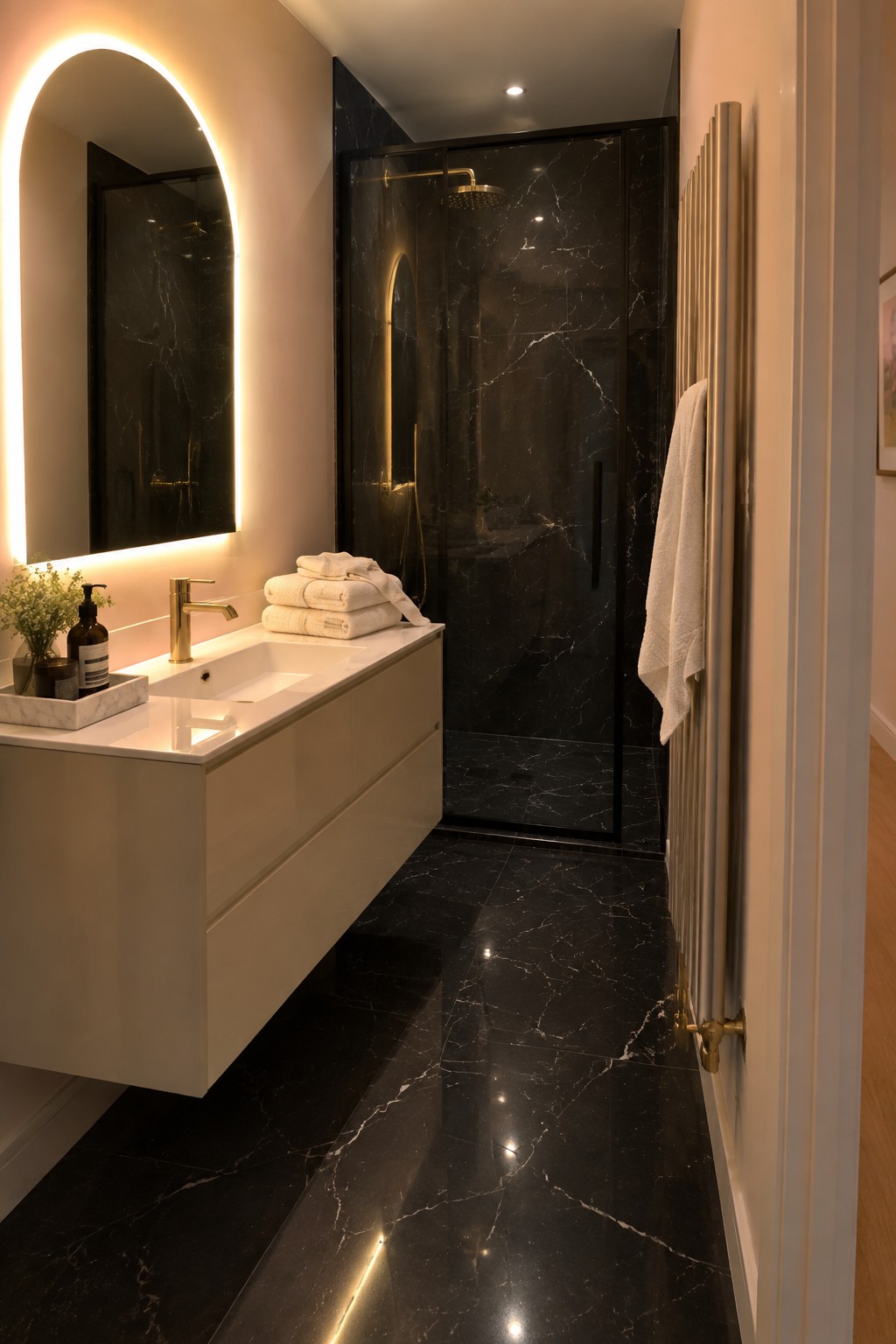 A modern bathroom with warm white walls paired with black marble tile and a floating vanity.
