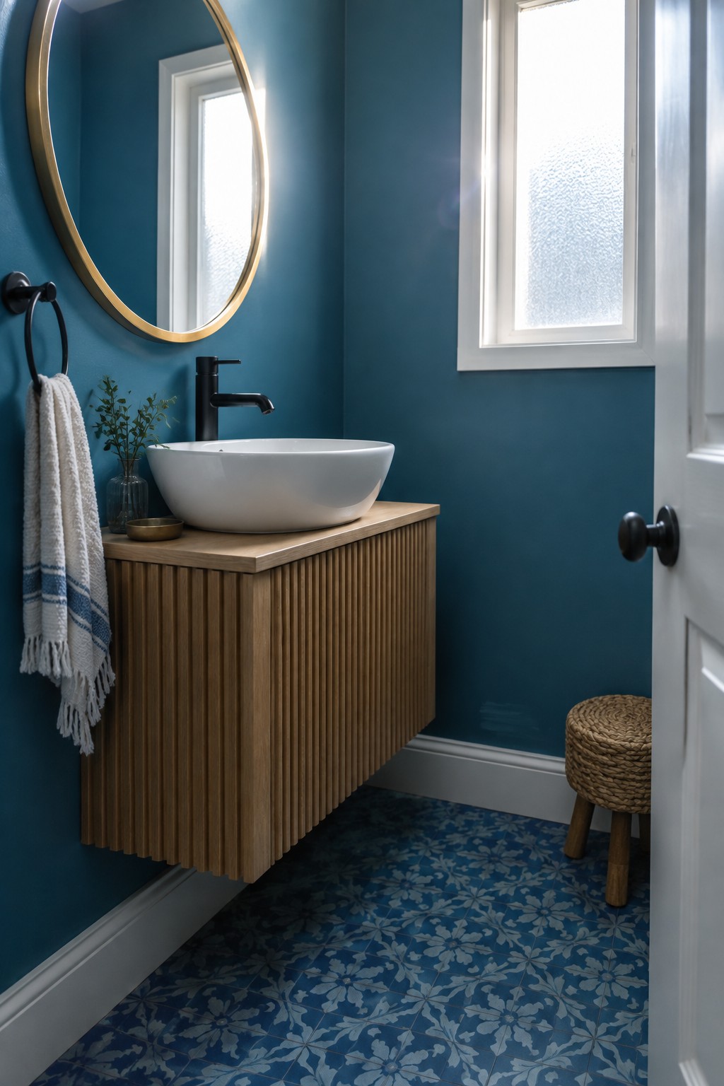 A small bathroom with deep teal walls and a floating wood vanity.