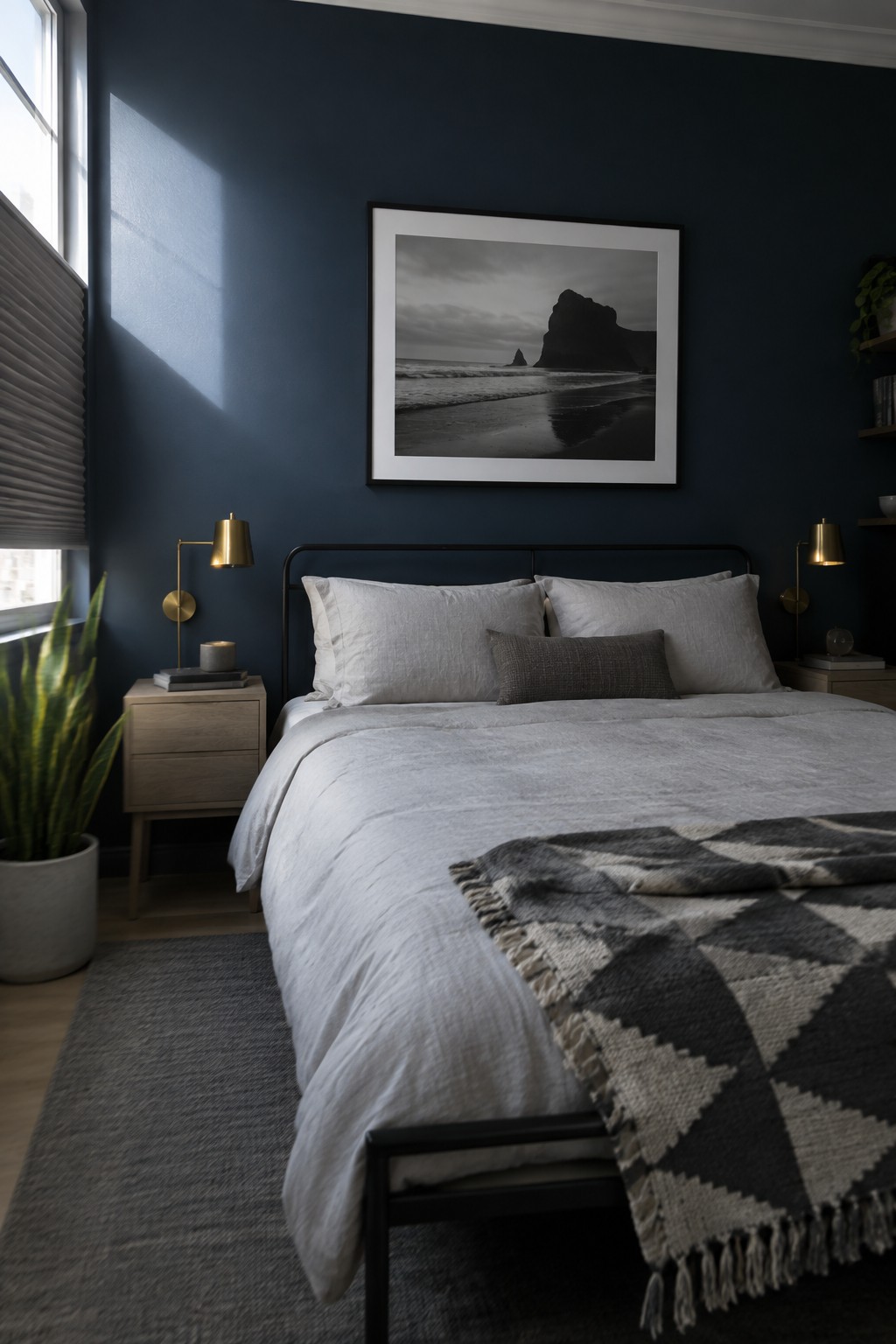 Modern bedroom with navy walls, white linens, black bed frame, and beach artwork