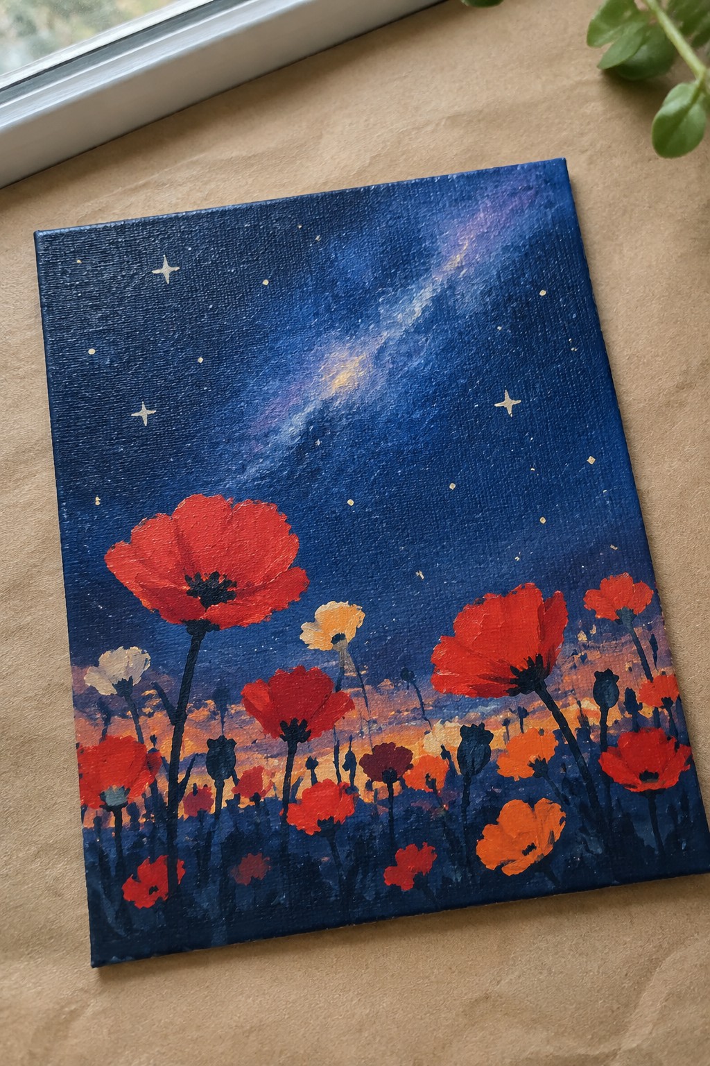 Red poppies painted on canvas beneath starry night sky with colorful sunset horizon