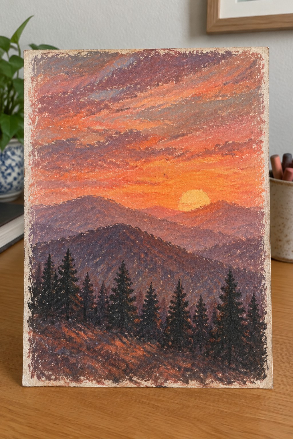 Pastel painting of orange sunset over purple mountains with dark pine trees