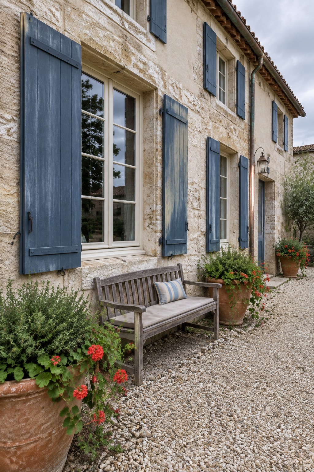 Blue shutters painted in a soft French blue on a stone house exterior.
