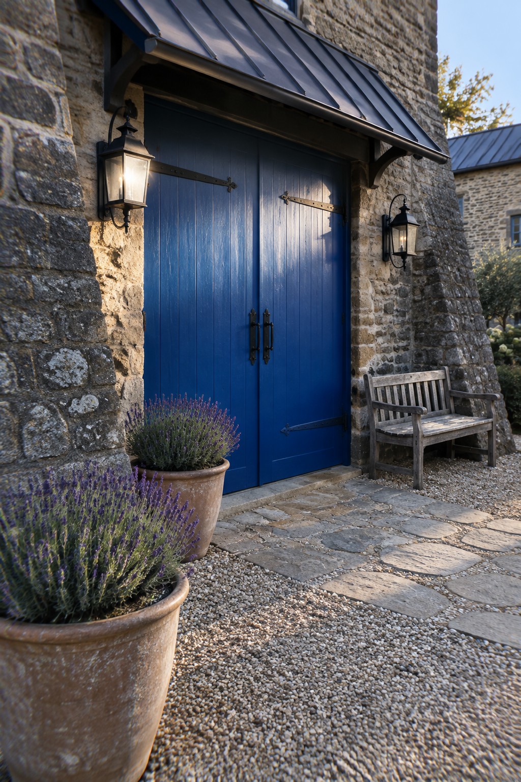 Deep French blue double doors set into a stone exterior wall.
