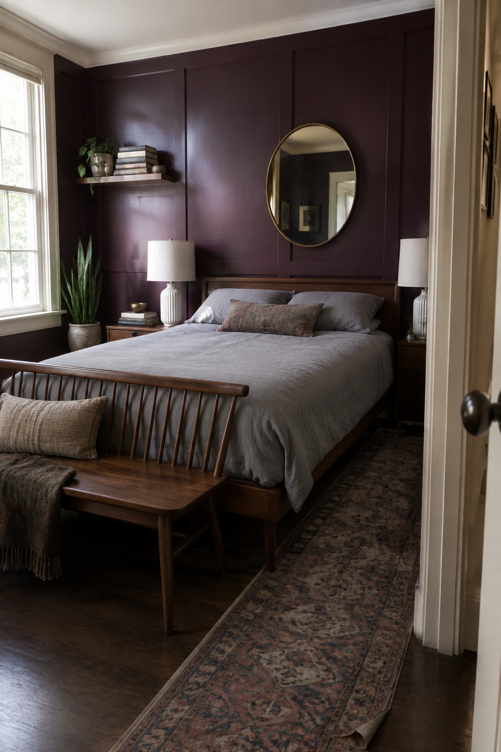 A bedroom with deep oxblood painted walls and dark wood furniture.
