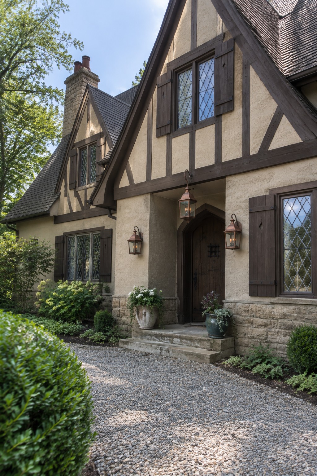 Warm beige stucco walls on a Tudor home with dark wood trim and stone foundation.