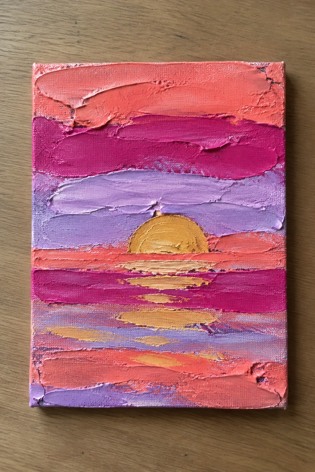 Thick impasto painting of yellow sun setting over pink-purple striped waters