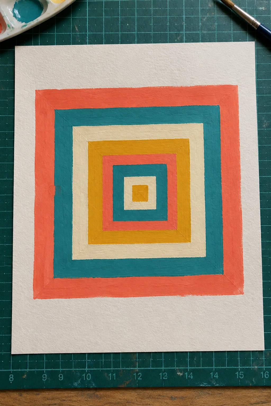 Concentric squares in coral red, teal, yellow, and beige on white paper