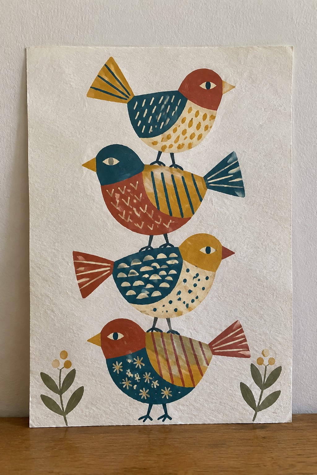 Four stacked colorful birds with patterned feathers above small plants in folk style.