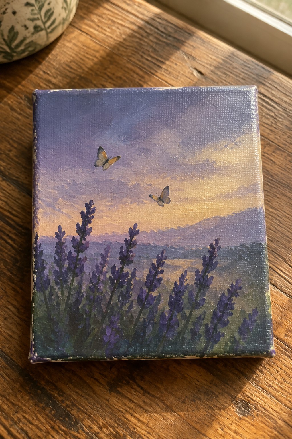 Miniature canvas painting of lavender blooms, two butterflies, and purple sunset over hills