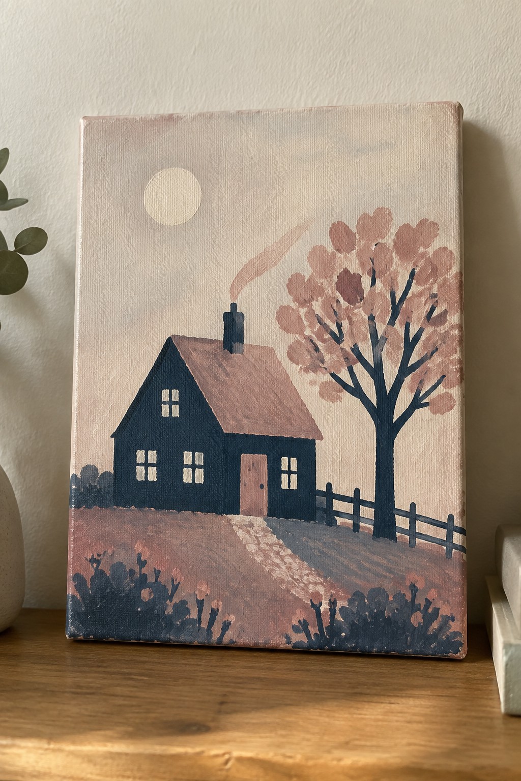 Dark blue house with smoking chimney beside pink tree, fence, and winding path.