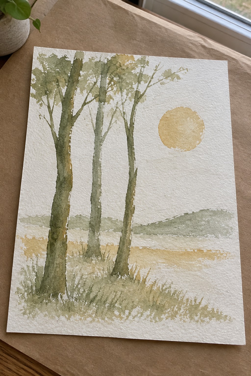 Watercolor landscape with three tall trees, golden sun, and rolling green hills.