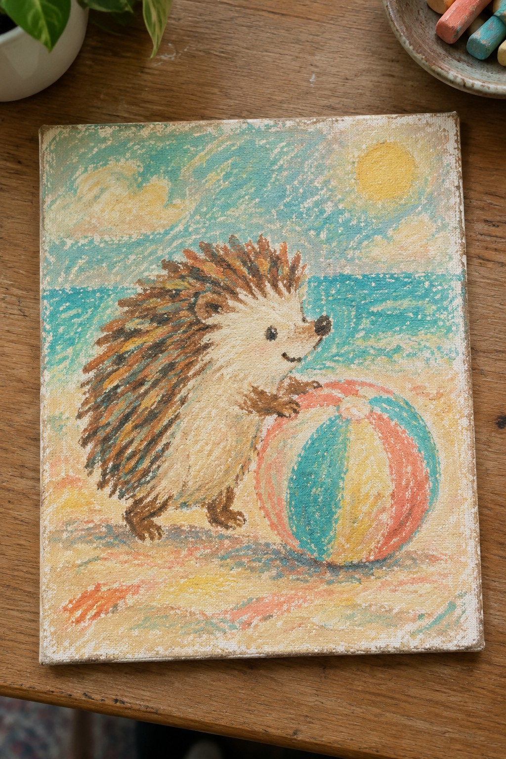 Pastel chalk painting of a hedgehog with a striped beach ball on a sunny beach.