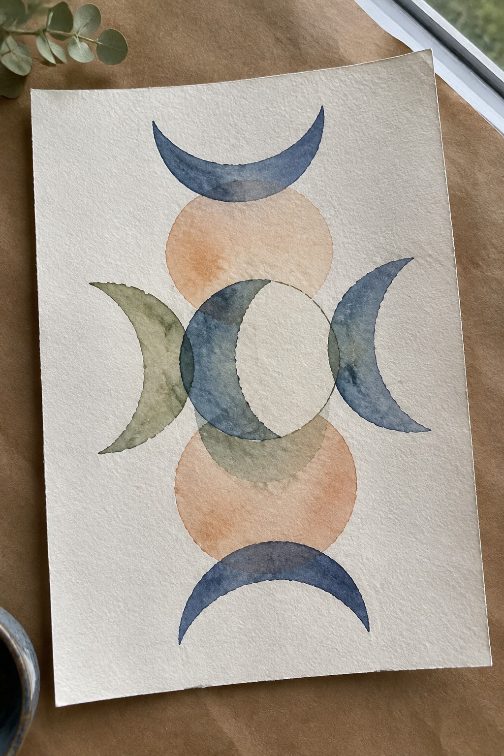 Abstract watercolor with blue crescents, orange circles, and green overlapping moons on paper.