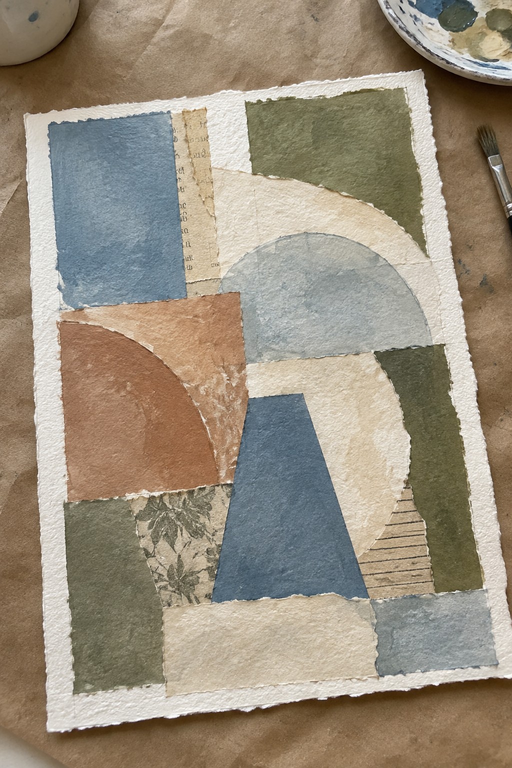 Abstract collage of torn papers in blue, green, terracotta, and beige geometric shapes.