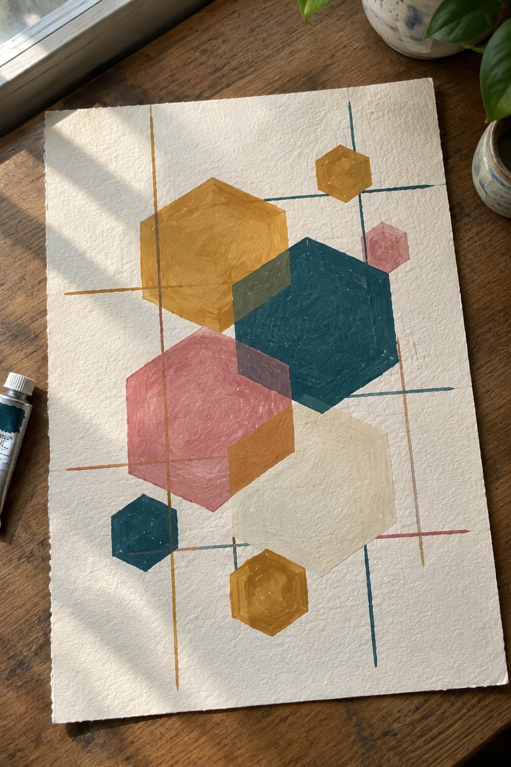Abstract painting of overlapping hexagons in yellow, teal, pink with thin lines on paper