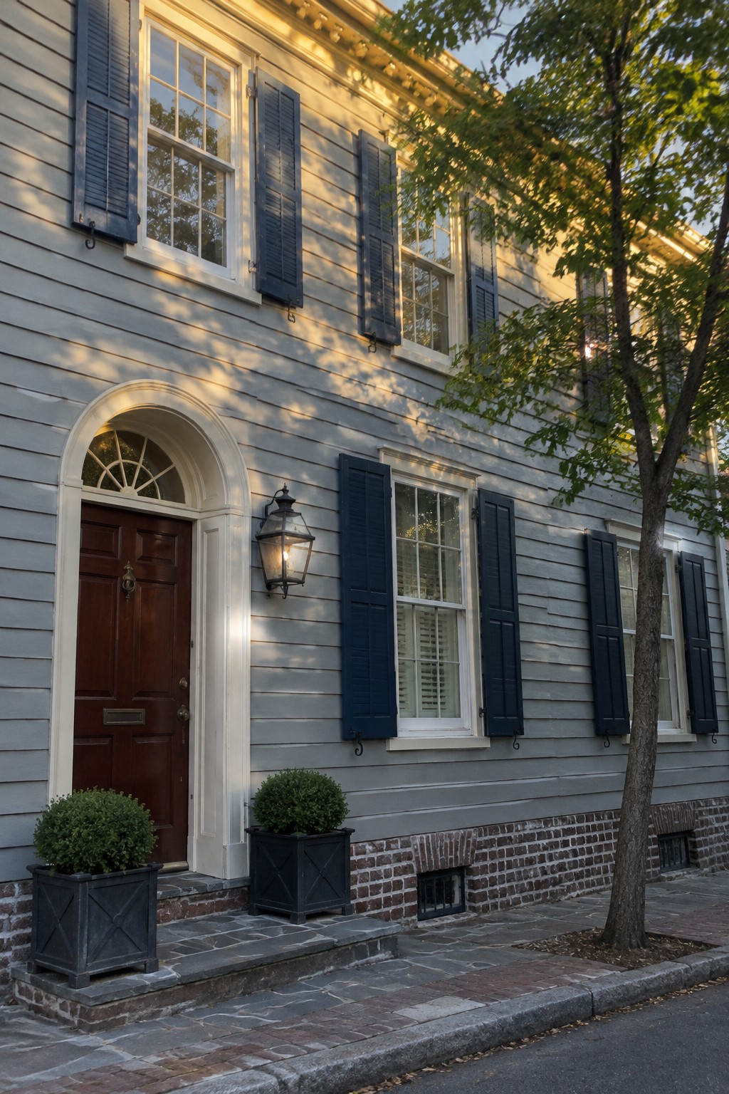 Light blue-gray siding on a house exterior with a red brick foundation.