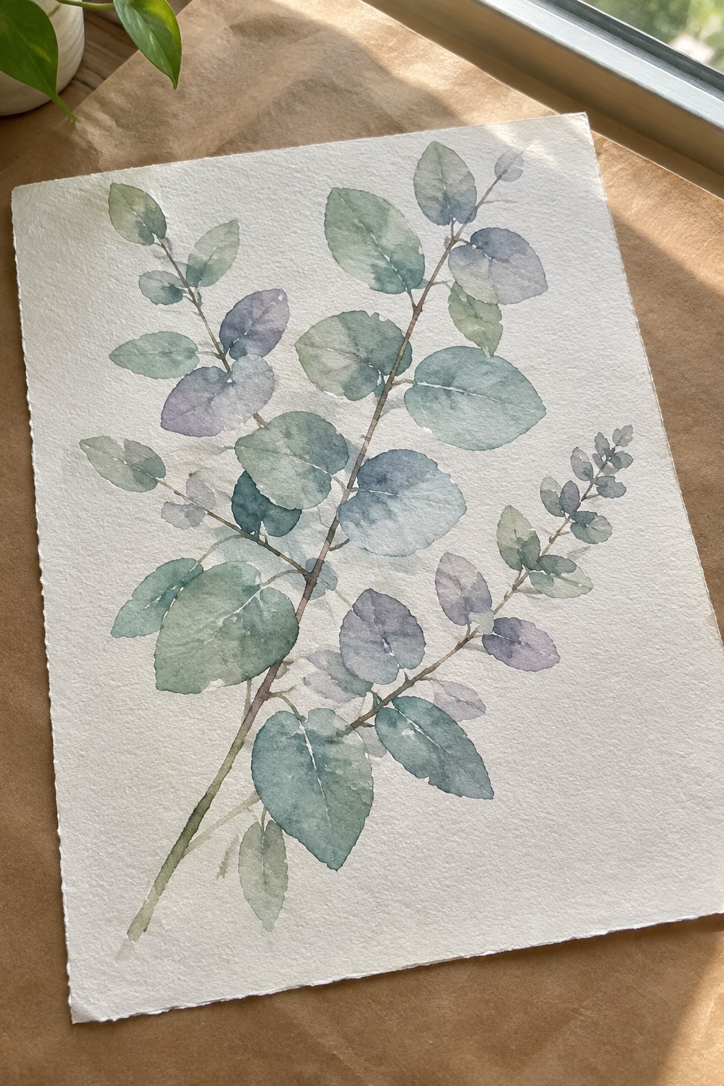 Watercolor eucalyptus branches with muted green blue and purple leaves on white paper