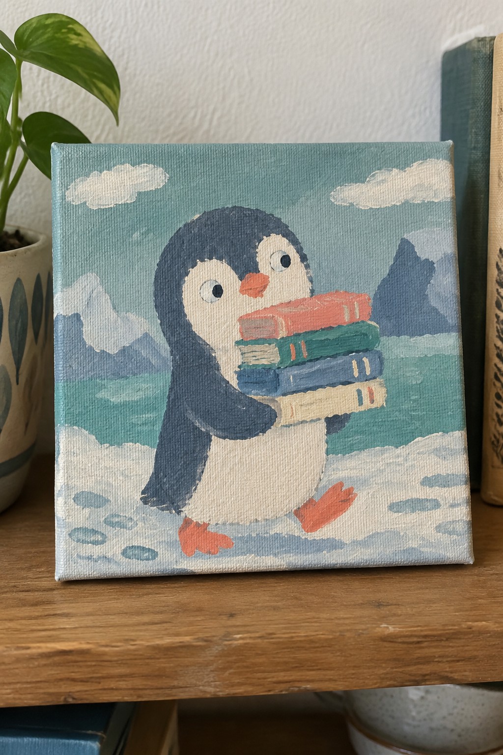 Cartoon penguin holding stack of books on snowy mountain landscape painting