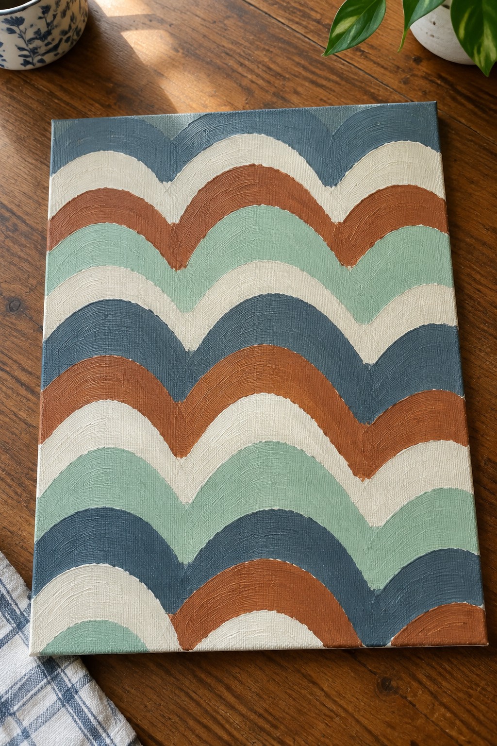 Abstract wavy painting in blue teal brown white on wooden table