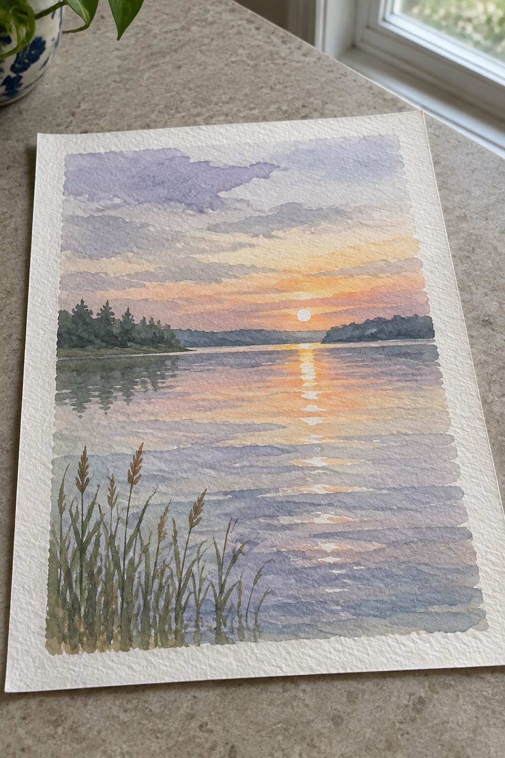 Watercolor sunset over calm lake with orange-purple clouds, tree-lined shore, and foreground reeds