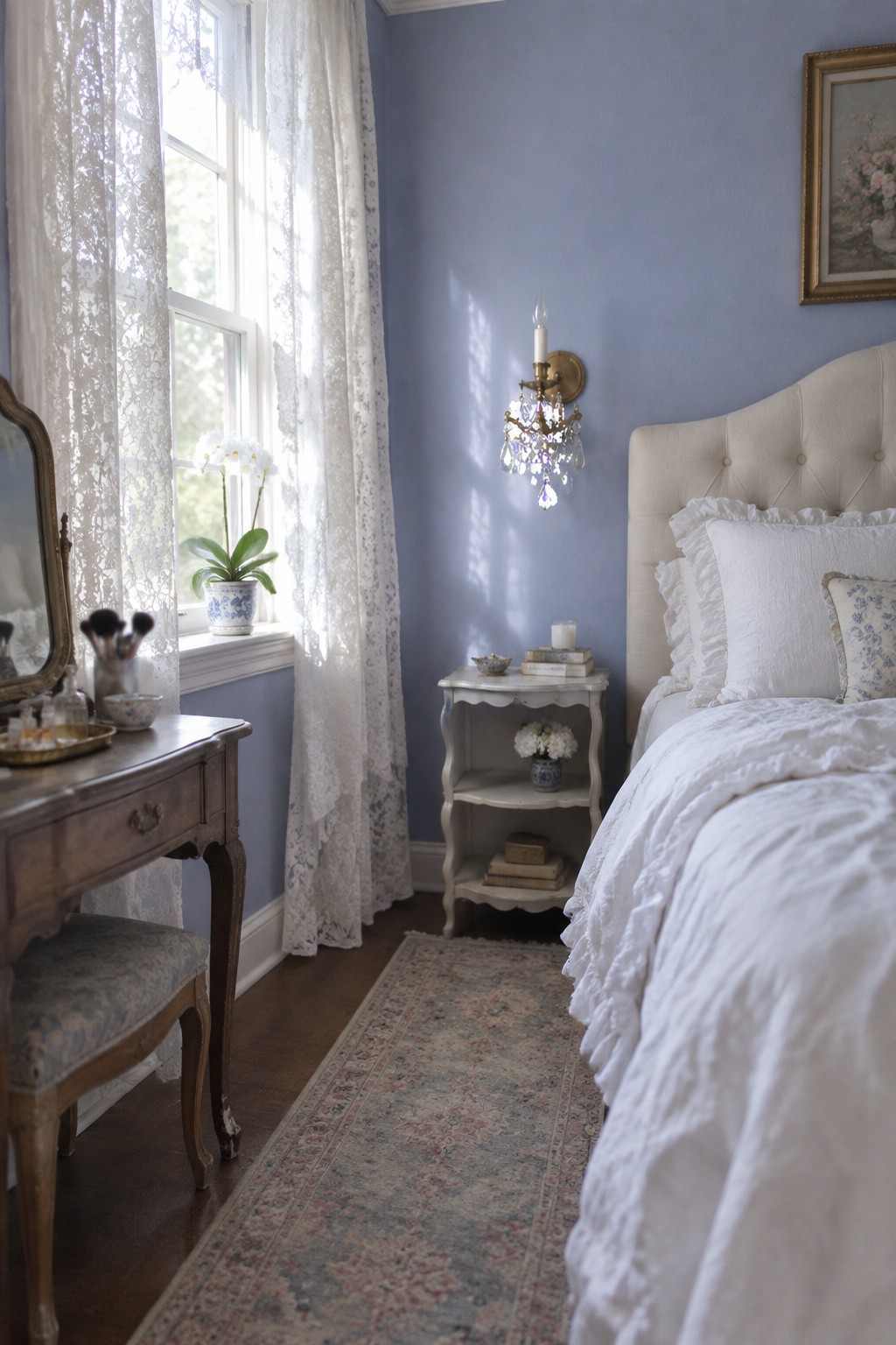 A bedroom with muted blue walls and white bedding beside a window.