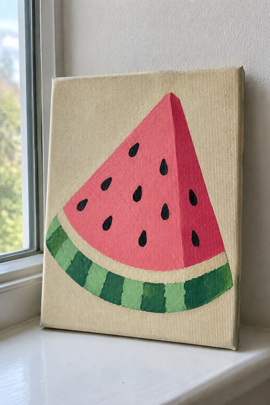 Acrylic painting of a watermelon wedge with pink flesh, black seeds, and green striped rind on a beige canvas resting on a windowsill.