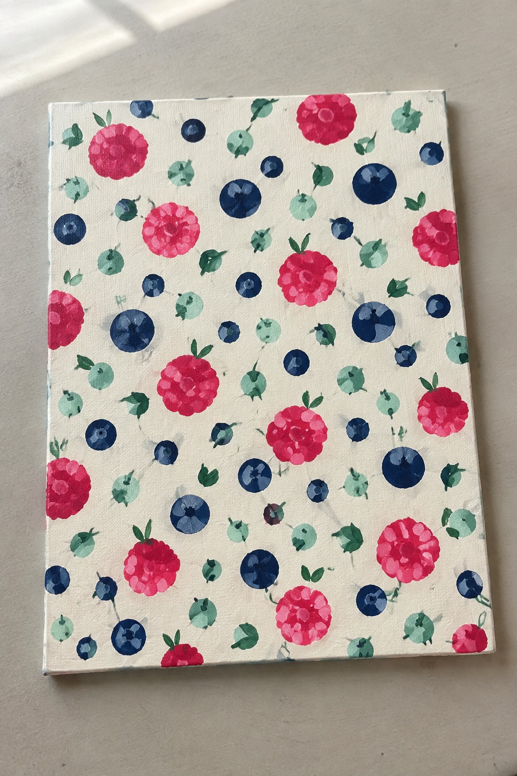Watercolor canvas with scattered pink flowers, blue berries, and green leaves.