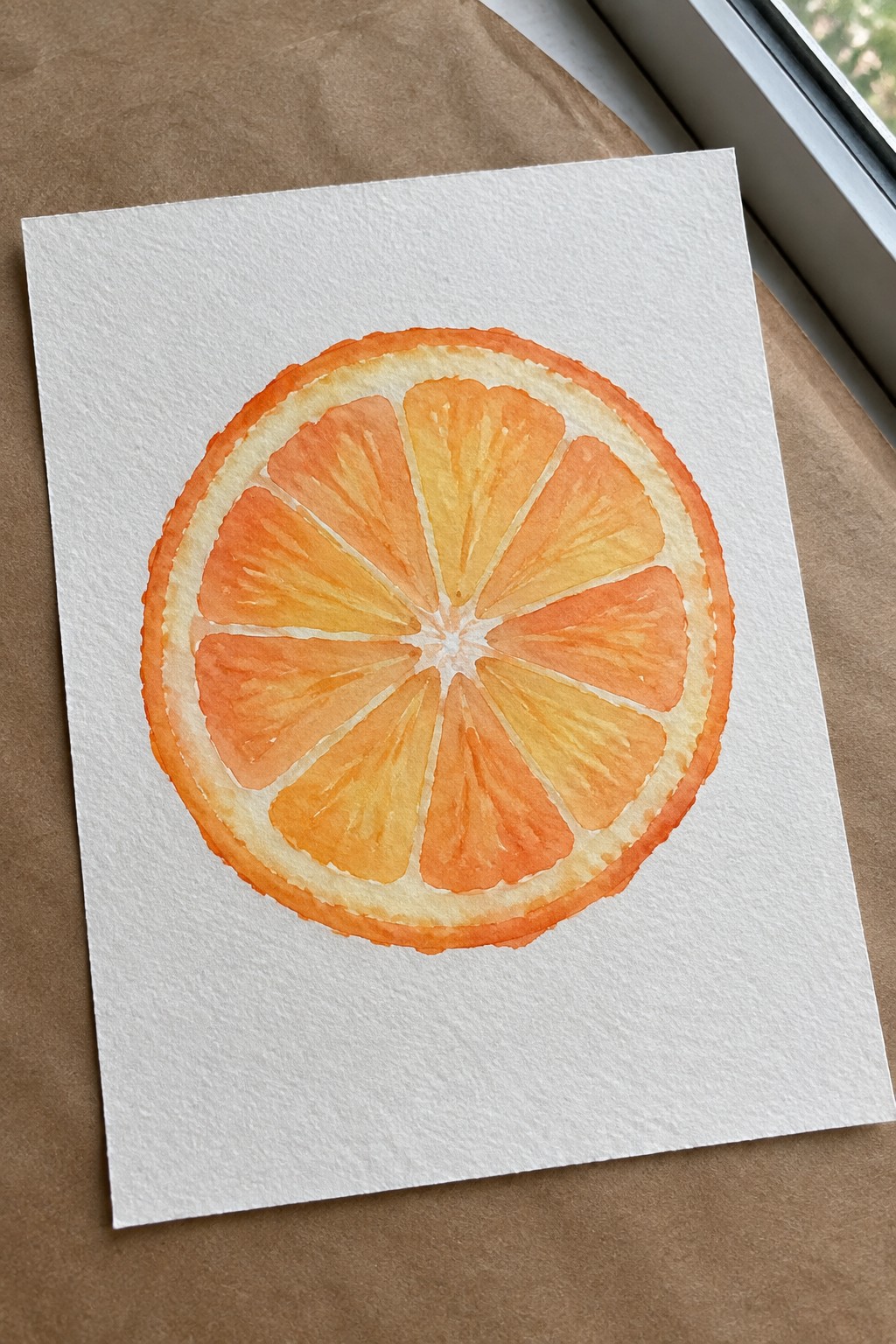 Watercolor painting of a sliced orange with vibrant orange and yellow segments