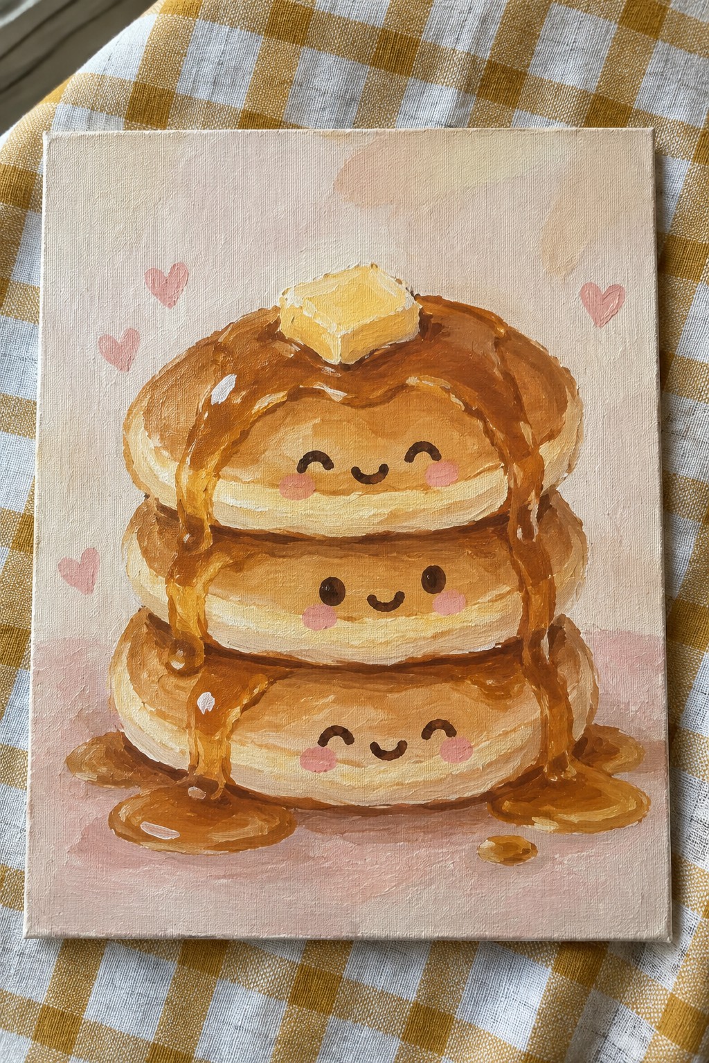 Cute kawaii pancake stack painting with faces, syrup drips, and butter on yellow gingham.