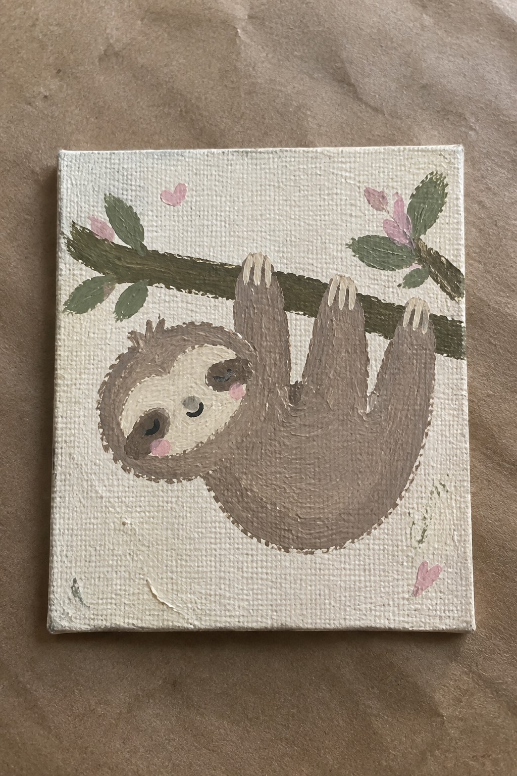 Cute brown sloth with pink cheeks hanging from leafy branch amid hearts on canvas.