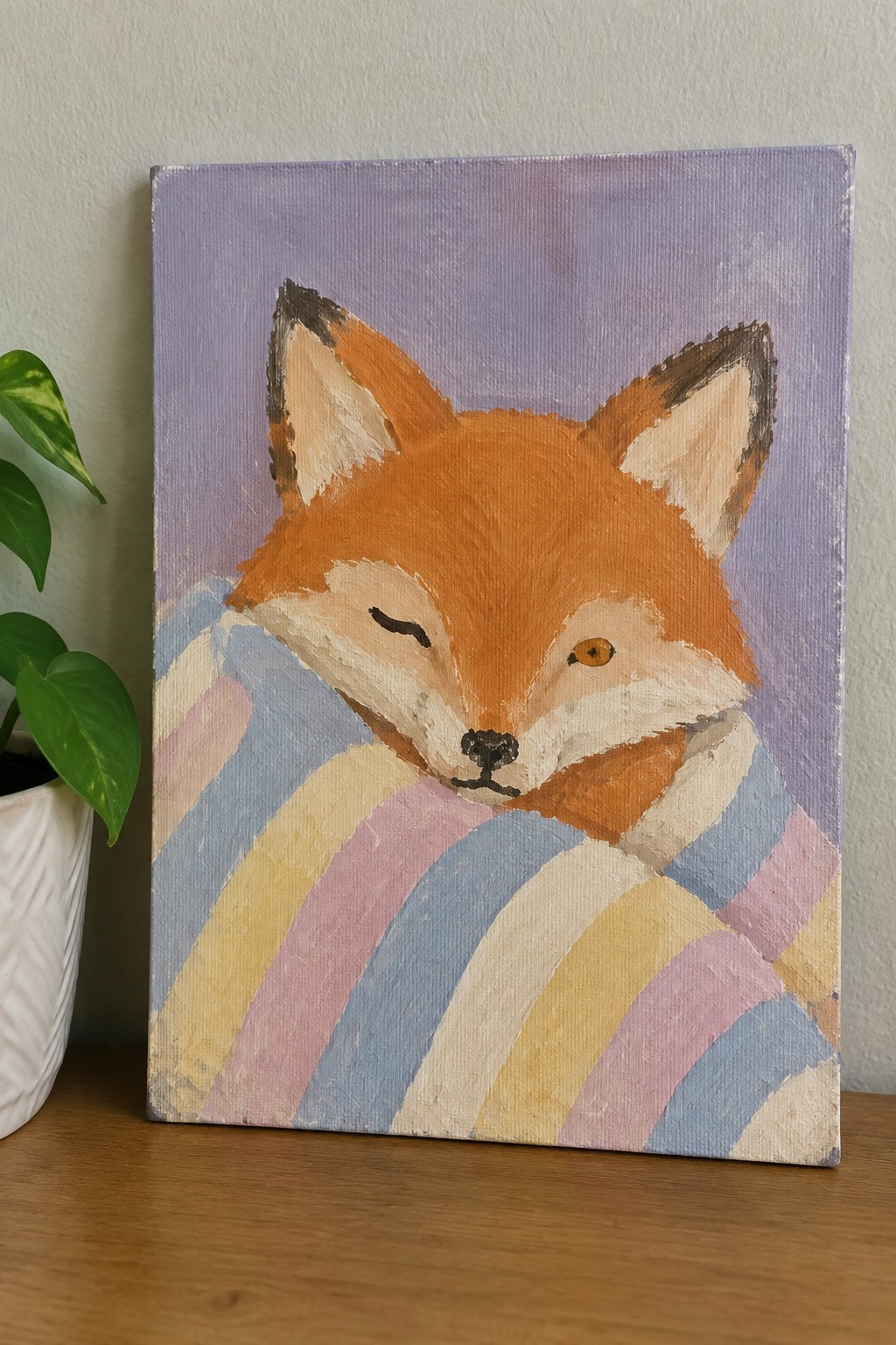 Acrylic painting of a fox peeking from a pastel striped blanket on purple background