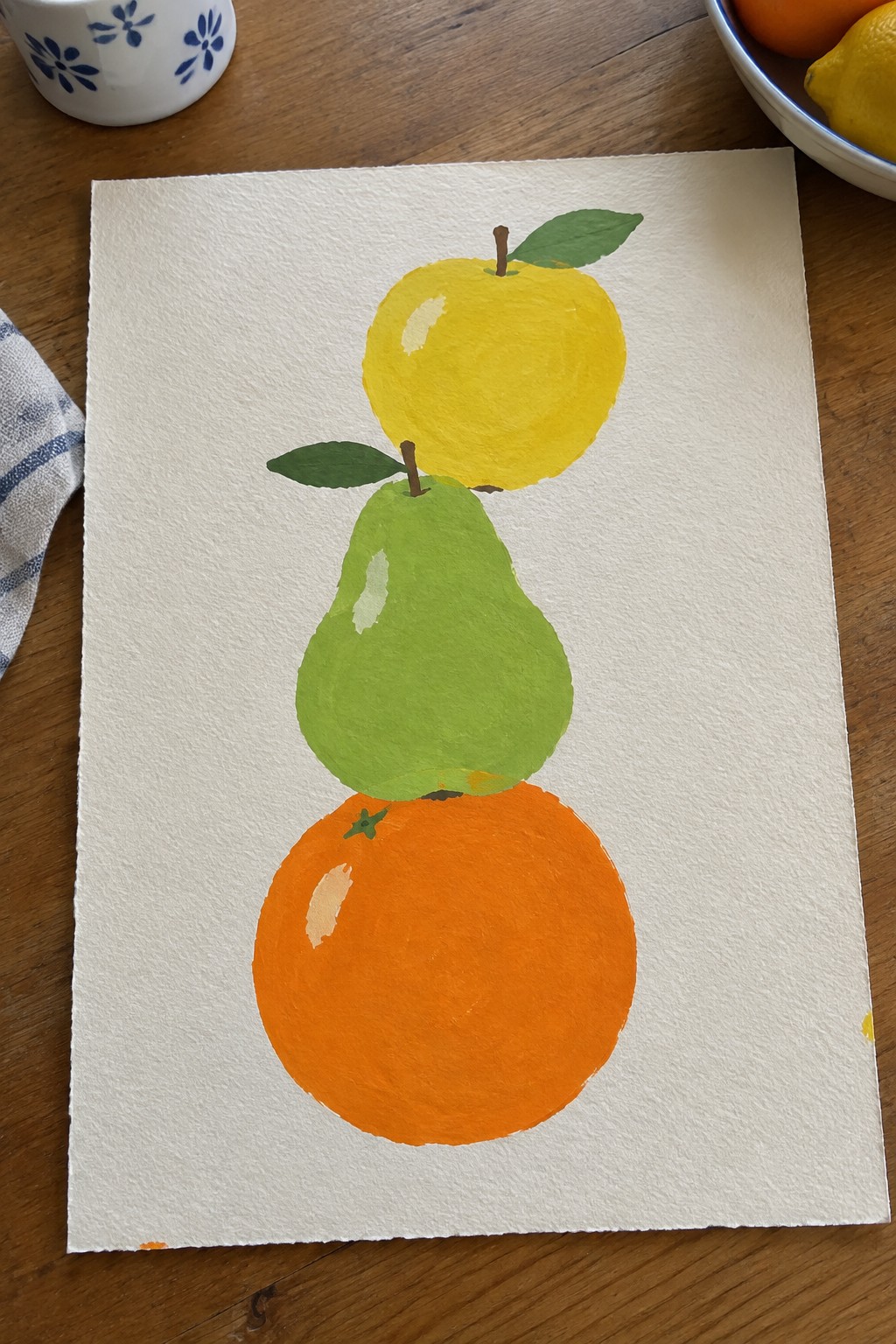 Watercolor painting of stacked yellow apple, green pear, and orange on paper