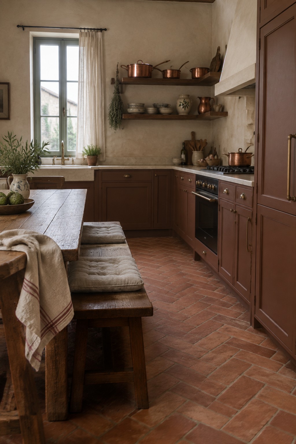 Warm terracotta brown kitchen cabinets in a rustic space with terracotta brick flooring.