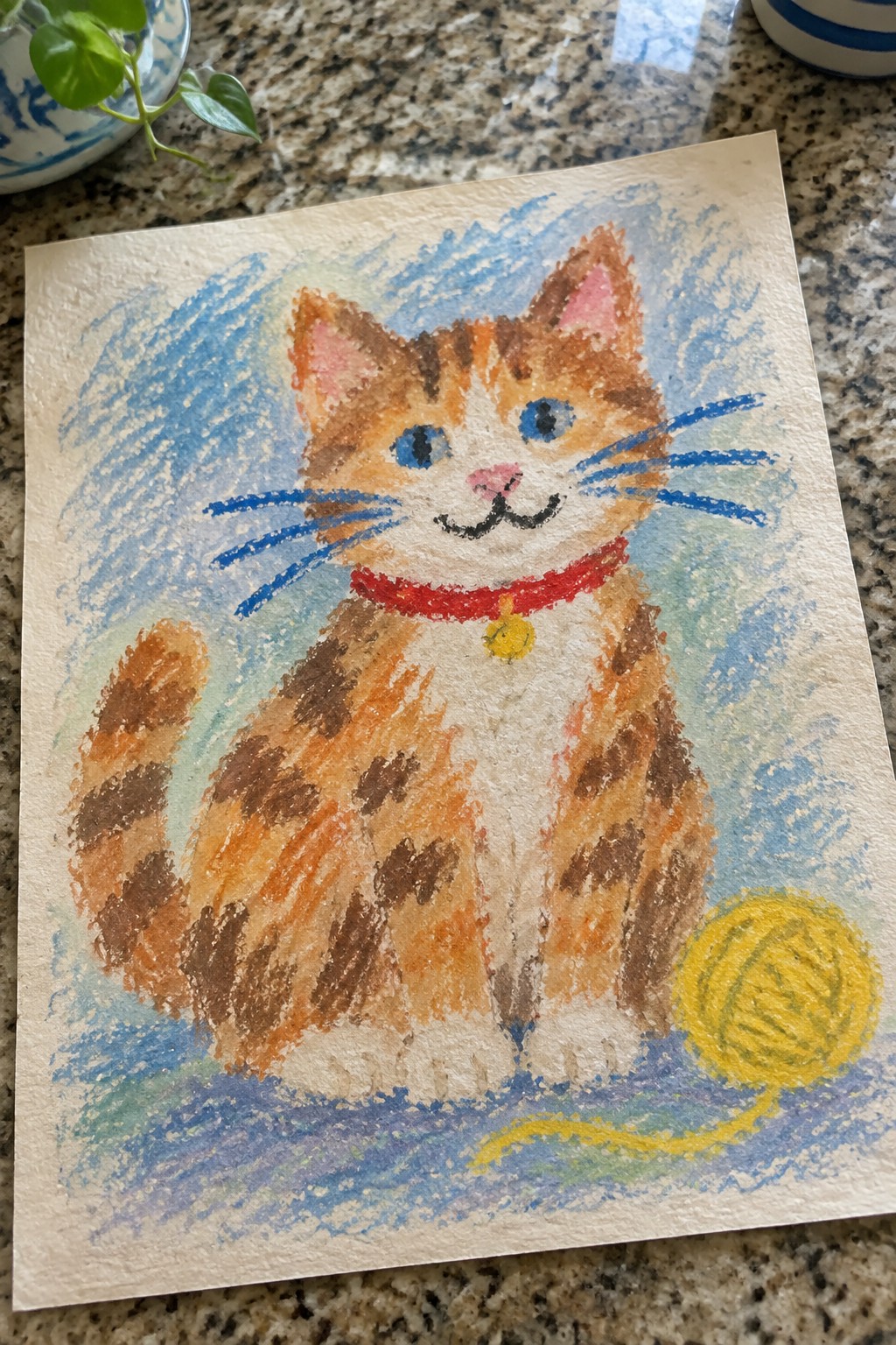 Colorful pastel drawing of orange tabby cat with red collar and yellow yarn ball.