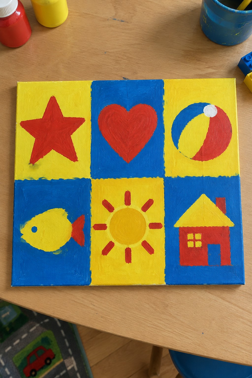 Colorful canvas with six panels showing red star, heart, beach ball, fish, sun, house