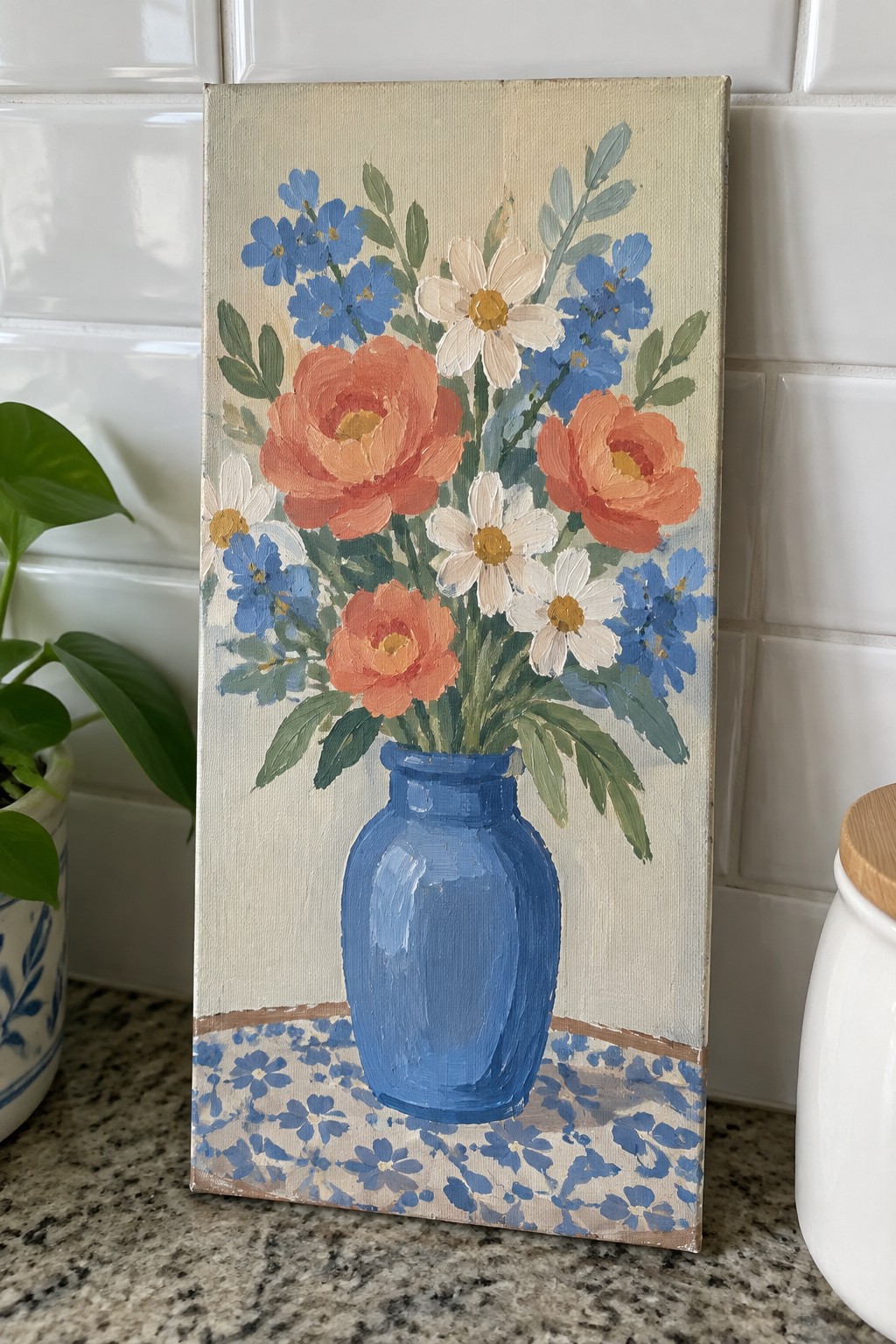 Still life painting of orange, white, and blue flowers in a blue vase