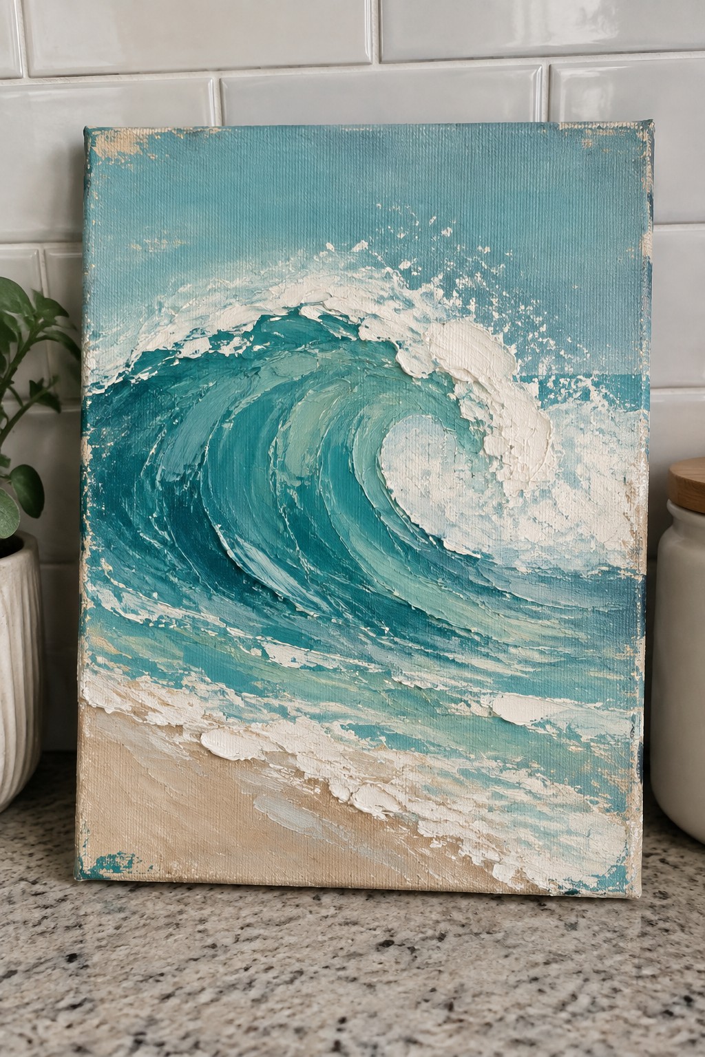 Canvas painting of turquoise ocean wave with white foam on speckled counter
