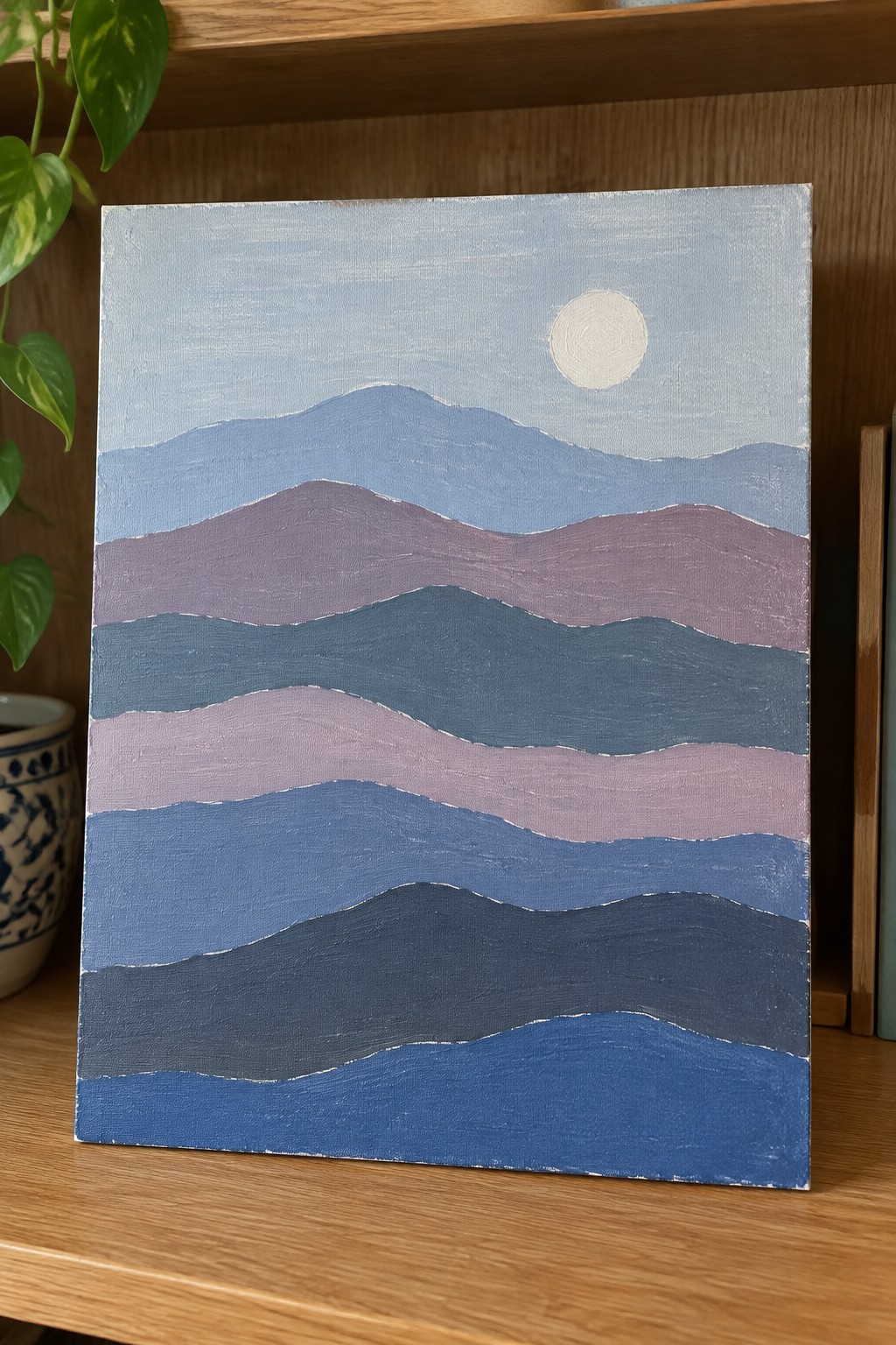 Abstract painting of wavy blue-purple mountain layers beneath a white sun on canvas.