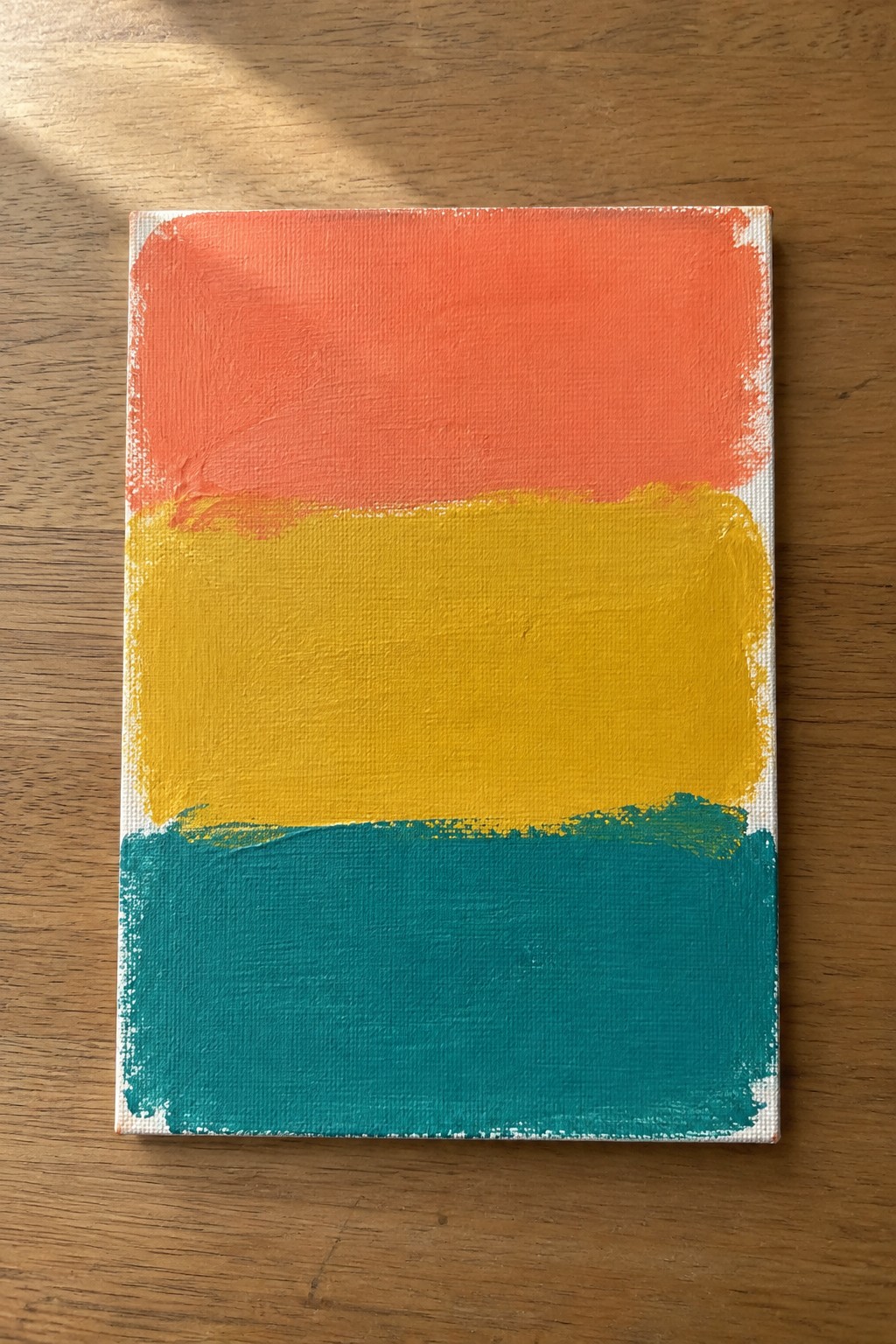 Abstract canvas with coral orange, yellow, and teal horizontal painted stripes on wood