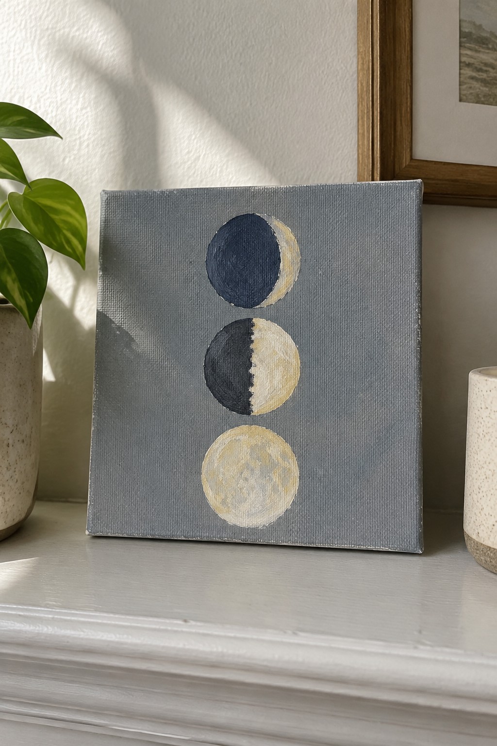 Small canvas with three moon phases in navy blue and gold on gray background